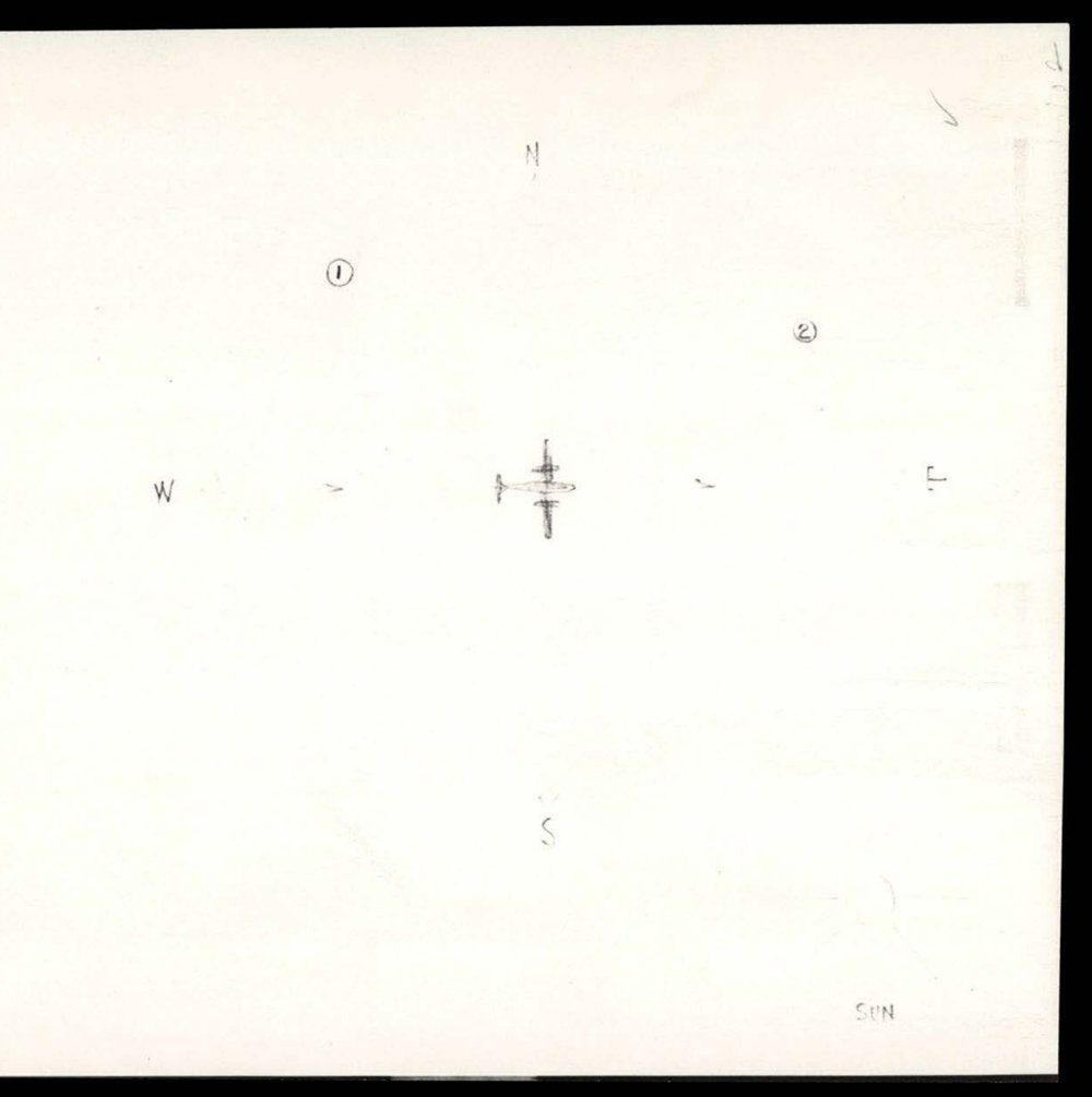 Folha branca com um pequeno avião bimotor desenhado a lápis no centro, as letras N, S, E e W em volta, os números 1 e 2 circulados acima do avião e a palavra SUN embaixo, à direita.