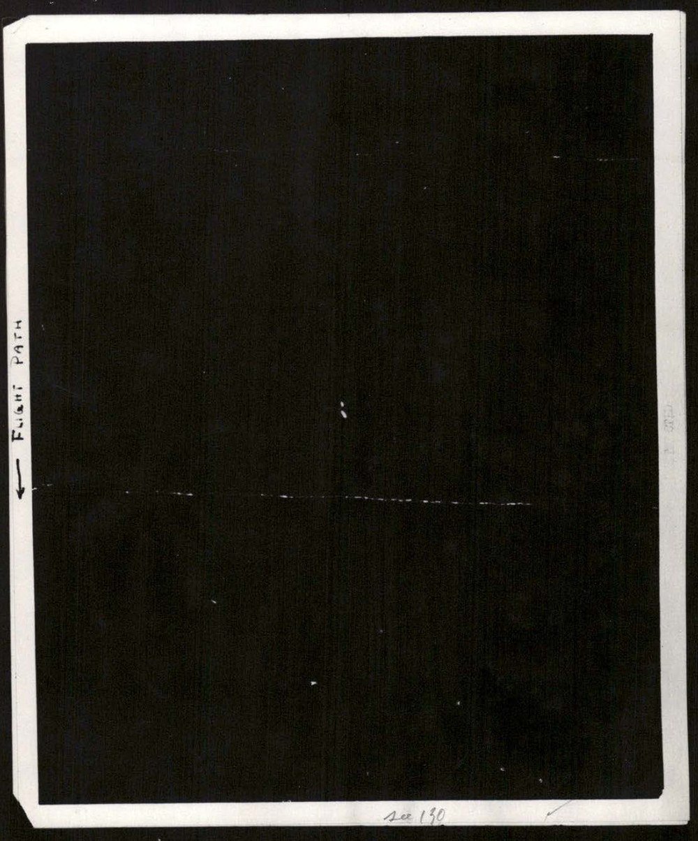 Fotografia quase toda preta com um fino traço branco interrompido na horizontal e dois pontinhos claros próximos ao centro; na margem esquerda, uma seta escrita à mão diz Flight Path.