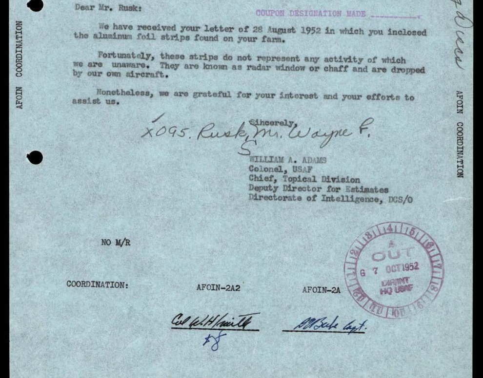 Carta datilografada em papel azulado com três parágrafos curtos, bloco de assinatura do coronel William A. Adams, carimbo redondo de saída e rubricas de coordenação no pé.