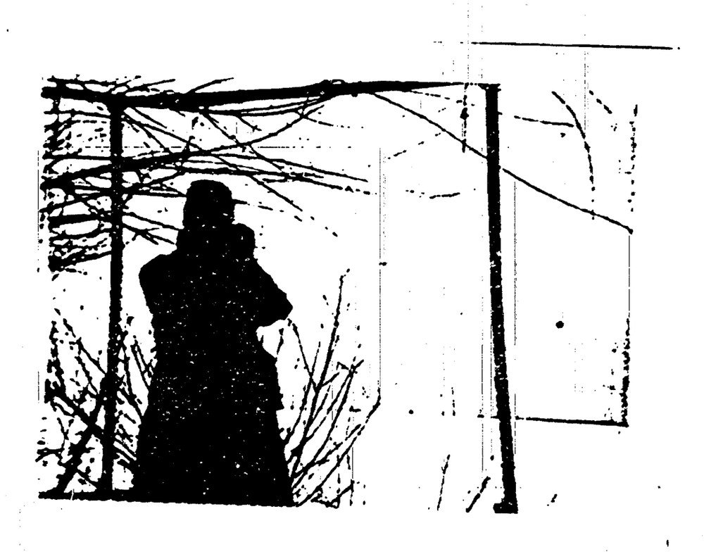 Foto em preto e branco de alto contraste: silhueta de uma pessoa entre dois postes ligados por uma barra, com galhos cruzando a imagem.
