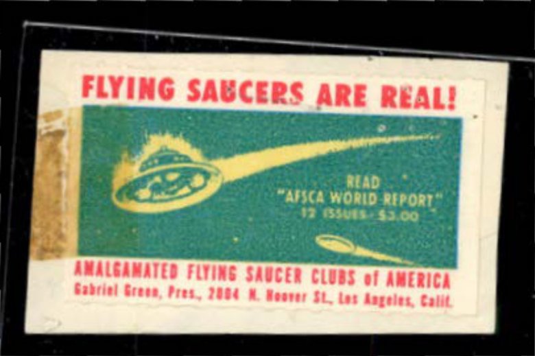 Selo retangular com letras vermelhas Flying Saucers Are Real e desenho amarelo de disco voador sobre fundo verde.