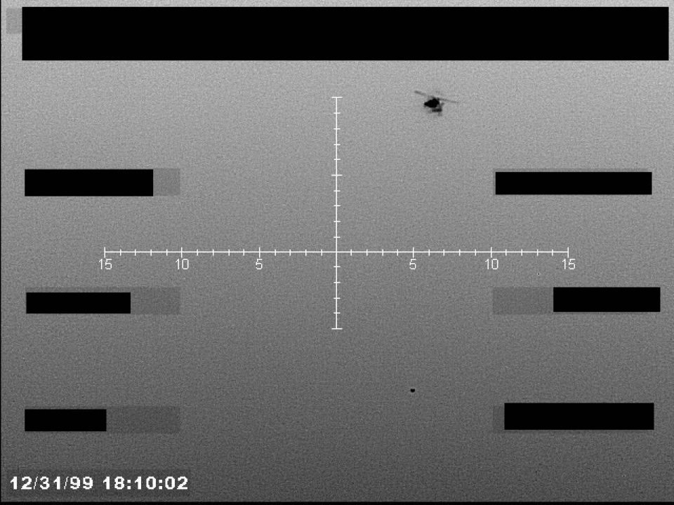 Imagem cinza de sensor com retícula em cruz, tarjas pretas e uma silhueta escura no alto semelhante a um helicóptero.